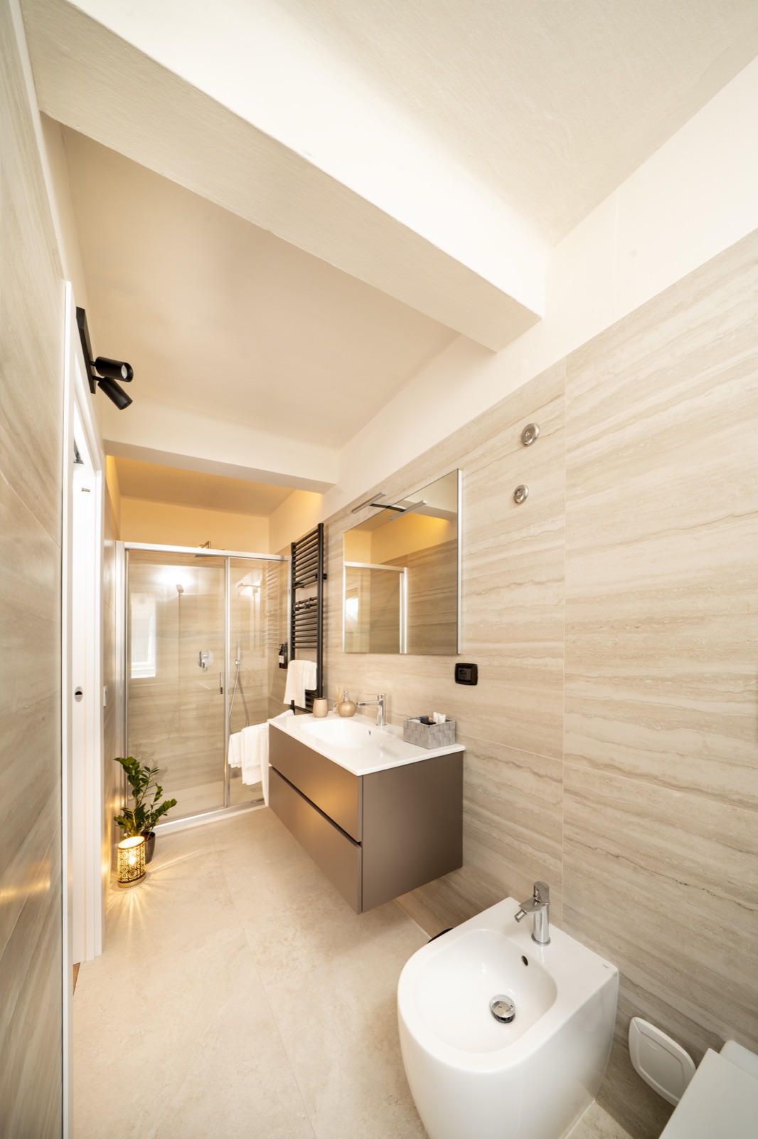 Il bagno in travertino chiaro, con il lavabo sospeso