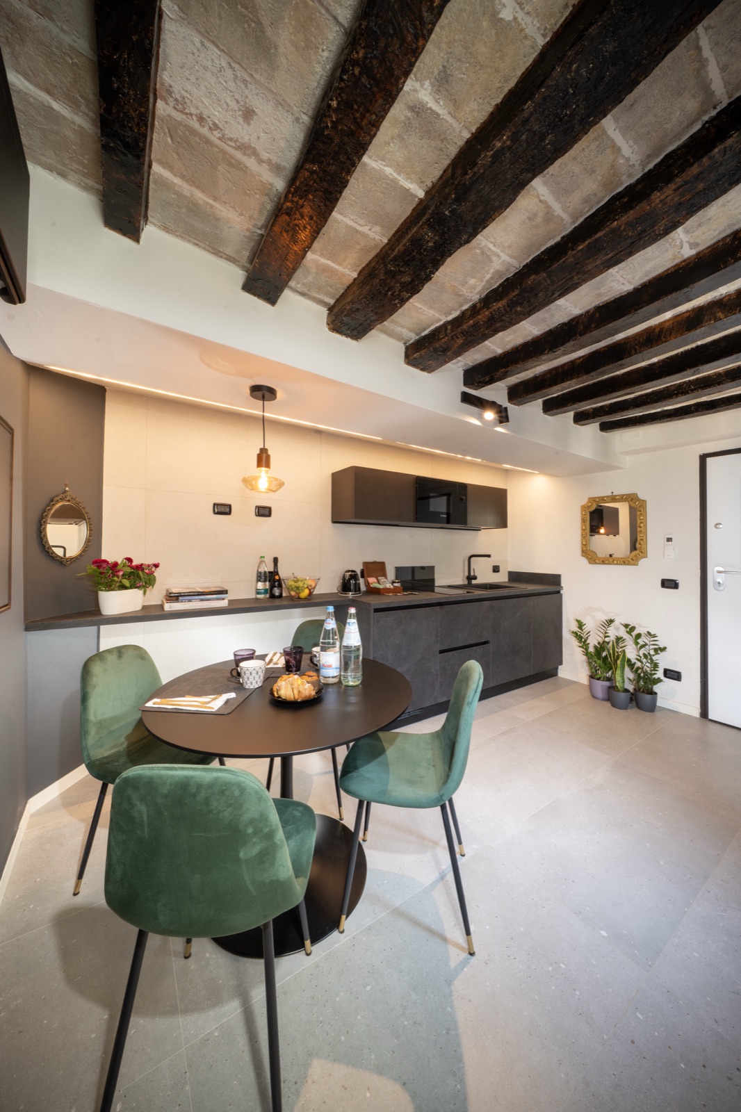 La cucina abitabile con il tavolo rotondo e le sedie verdi
