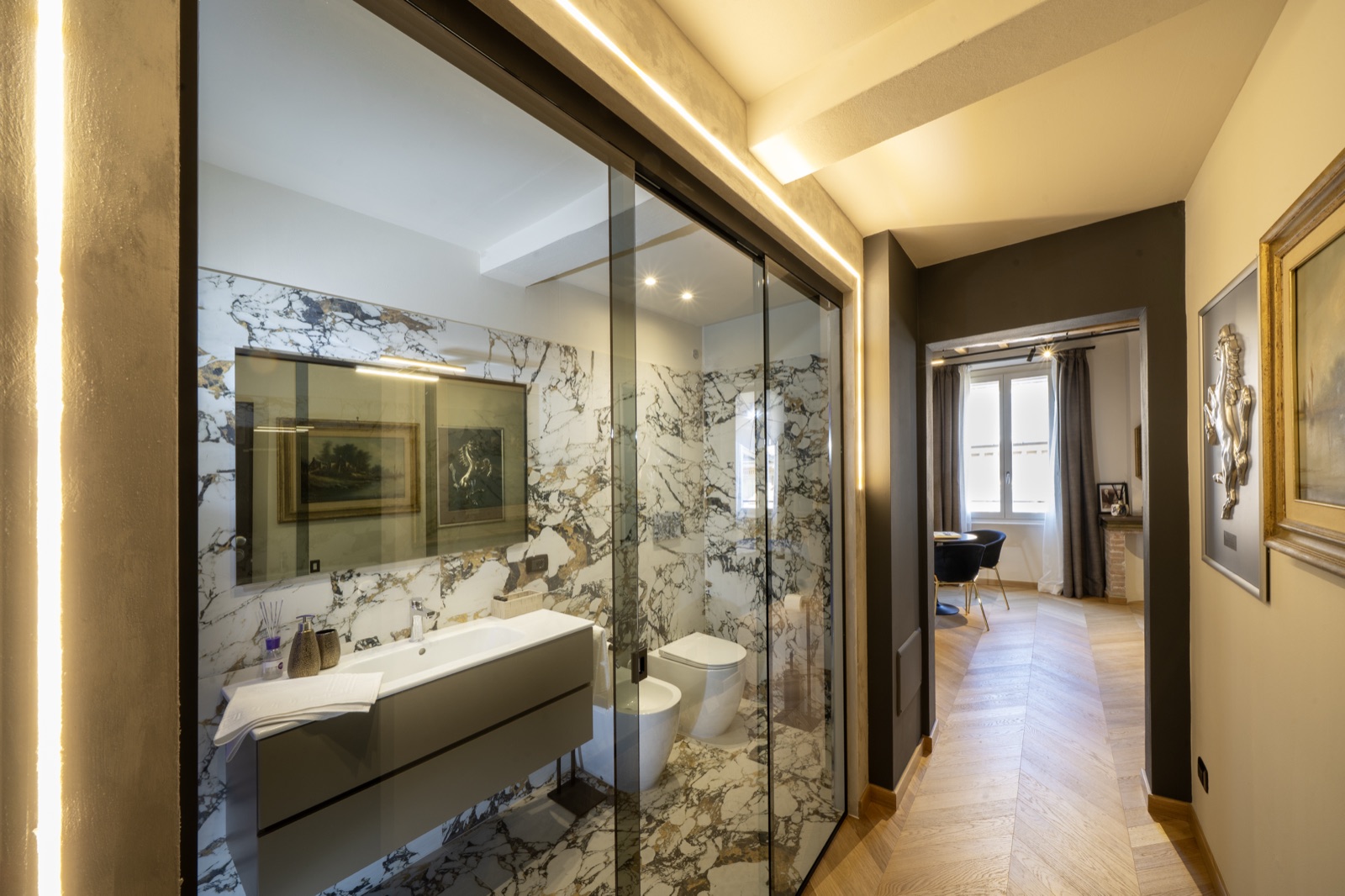 Il bagno in marmo con la doccia walk-in e la cromoterapia accesa
