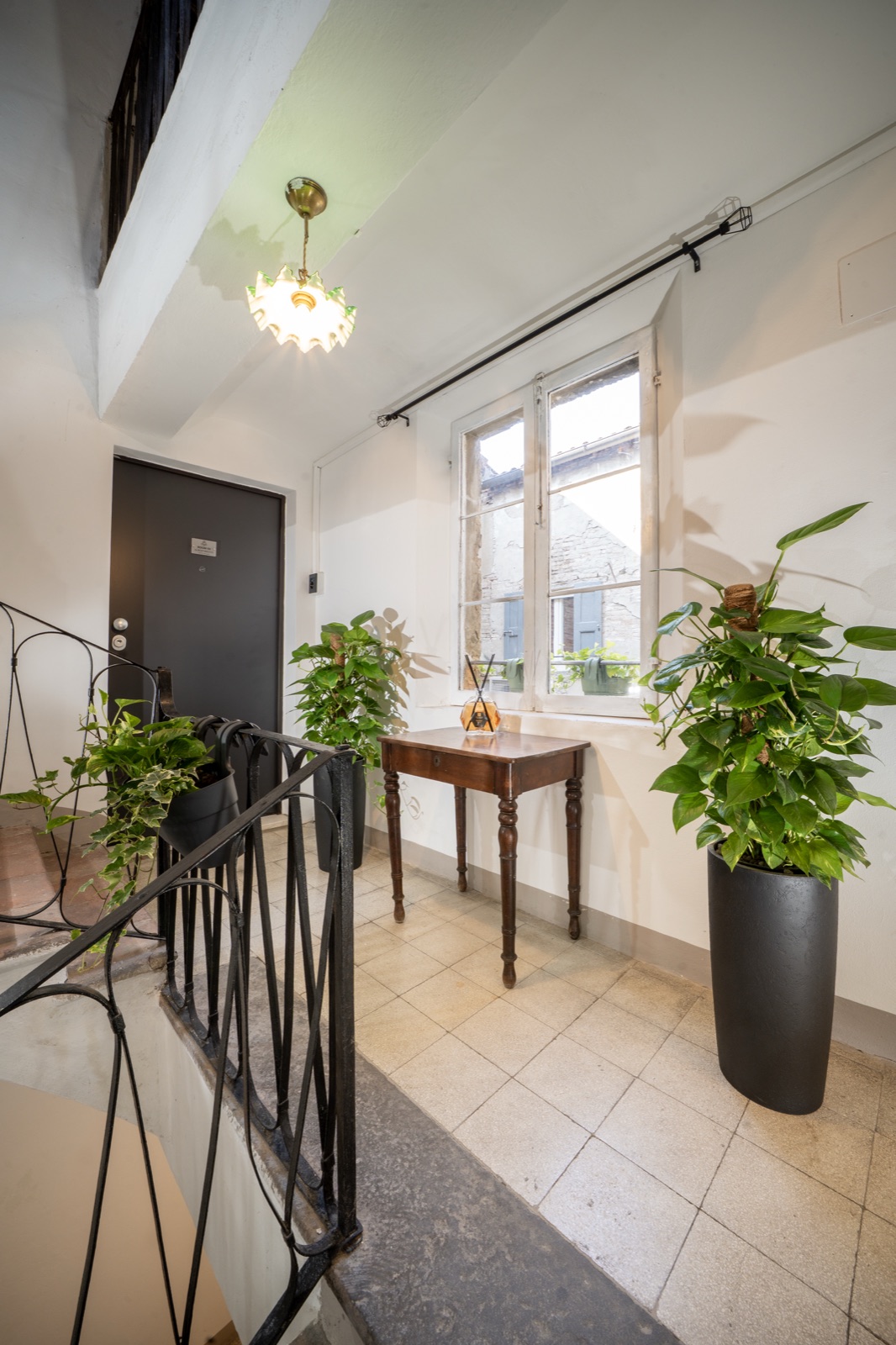 The fourth-floor landing, with plants and an antique console table